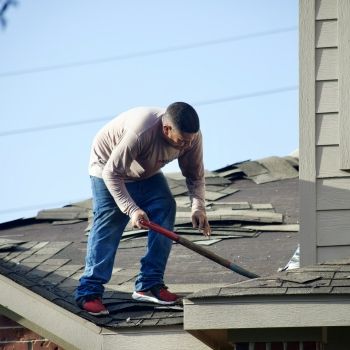 Roofing professional fixing a residential roof