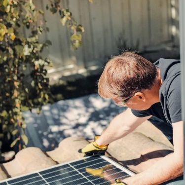 Solar worker installing panels on a residential roof